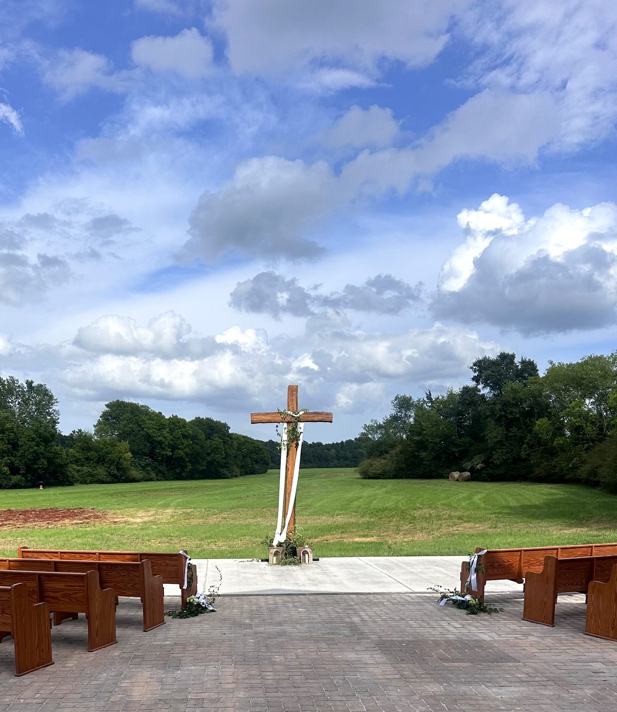 The ceremony court and cross seen across the open field under a big sky