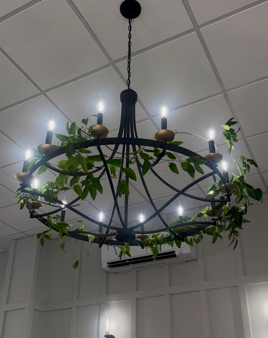 Iron chandelier wrapped in greenery over the main floor