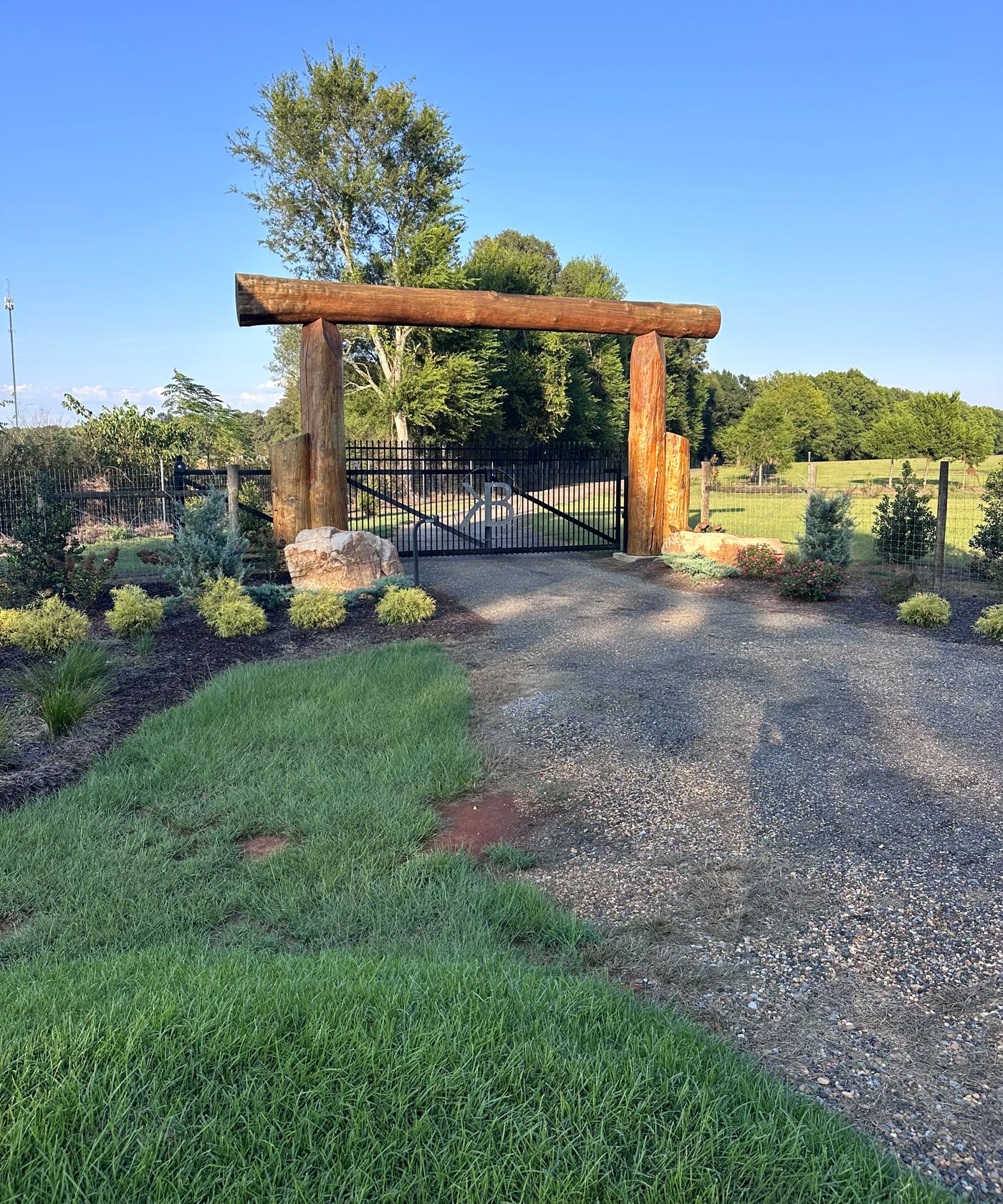 The timber entrance gate over the gravel drive, with fields beyond